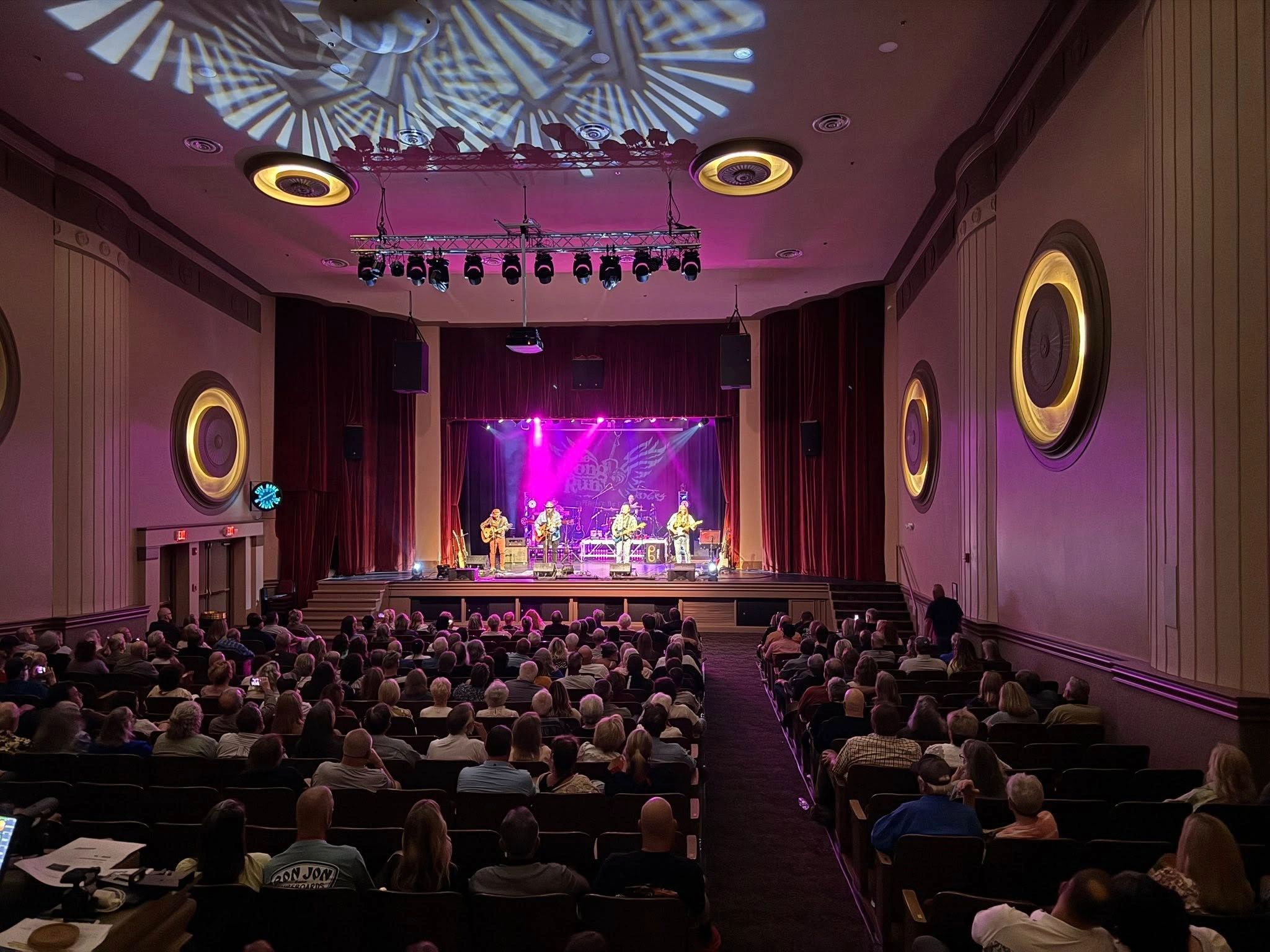 Packed theater audience watching live performance